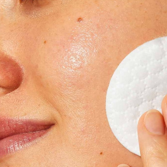 Model using CeraVe Micellar Cleansing Water with Niacinamide for All Skin Types 295ml with a cotton pad on her face